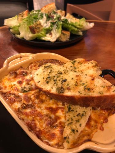a plate of food with pizza and a salad at Cafe Moto Hostel in Puerto Princesa City