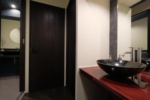 a bathroom with a black bowl sink on a counter at 国際通りまで車で5分 那覇空港まで車で8分 最大15名 As bld in Makishimachi