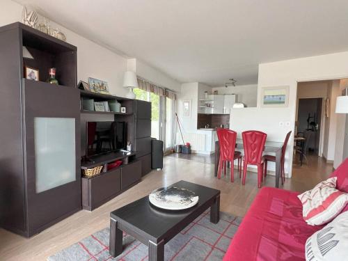 un salon avec un canapé rouge et une table dans l'établissement La Baule: Bel appartement à 250m de la plage et des commerces - FR-1-392-238, au Pouliguen