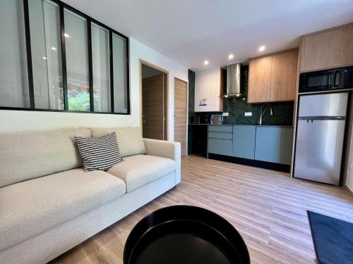 un salon avec un canapé et une cuisine dans l'établissement Appartement 2 Pièces avec Terrasse - Centre-ville & Proche Mer - FR-1-226B-210, à Cavalaire-sur-Mer