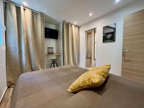 - une chambre avec un lit doté d'un oreiller jaune dans l'établissement Appartement 2 Pièces avec Terrasse - Centre-ville & Proche Mer - FR-1-226B-210, à Cavalaire-sur-Mer