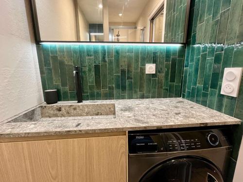 une salle de bain avec un lavabo et une machine à laver dans l'établissement Appartement 2 Pièces avec Terrasse - Centre-ville & Proche Mer - FR-1-226B-210, à Cavalaire-sur-Mer