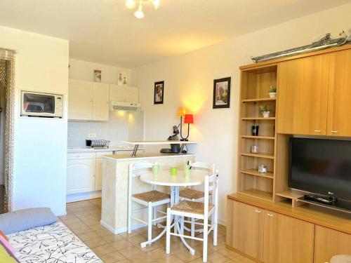 - une cuisine avec une petite table et une télévision dans la chambre dans l'établissement Appartement 2 pièces coin nuit, balcon sud, proche plage et commerces, garage inclus, 5 couchages - FR-1-251-838, à Bormes-les-Mimosas