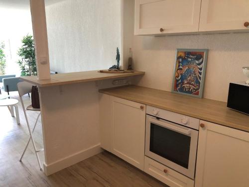 une cuisine avec des armoires blanches et un comptoir dans l'établissement Charmant T2 avec parking et accès plage à Sète - FR-1-472-204, à Sète