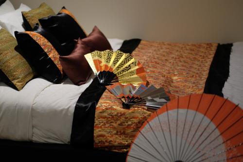 a bed with many pillows and a fan on it at 国際通りまで車で5分 那覇空港まで車で8分 最大15名 As bld in Makishimachi