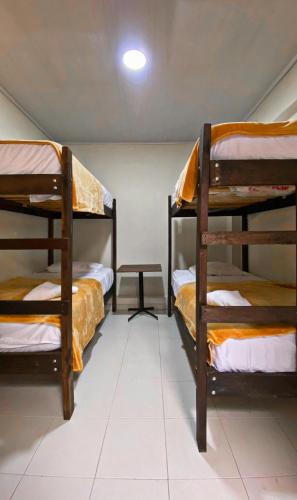 a room with three bunk beds and a table at hostal casa la abuela habitación 209 in Santa Rosa de Cabal