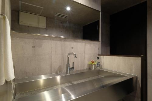 a stainless steel sink in a bathroom with a mirror at 国際通りまで車で5分 那覇空港まで車で8分 最大15名 As bld in Makishimachi