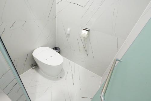 a white bathroom with a toilet and a shower at Dongho Beach Hotel in Gochang 