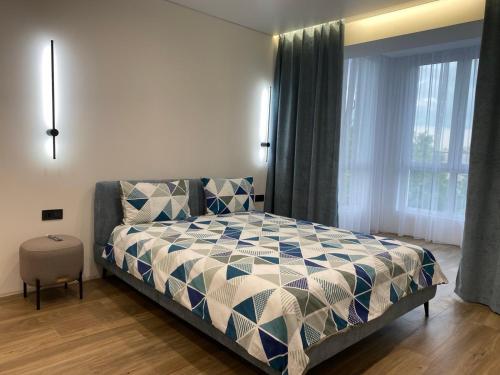 a bedroom with a bed and a large window at Апартаменти в районі АВТОВОКЗАЛУ Поблизу Обласноі лікарні ЖК Great House,ЖК Арена in Rivne