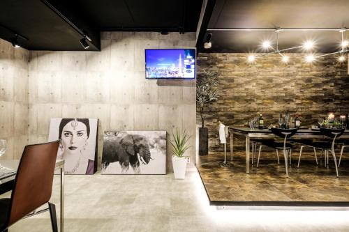 a dining room with a table and a tv on the wall at 国際通りまで車で5分 那覇空港まで車で8分 最大15名 As bld in Makishimachi