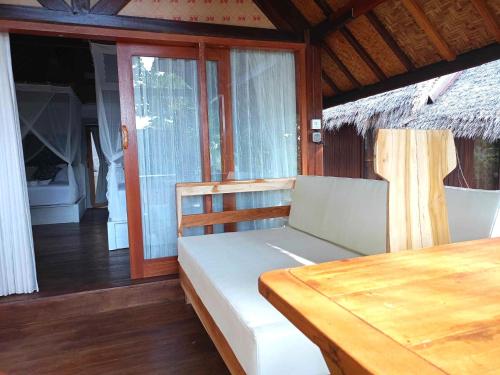 a bedroom with a bed and a wooden table at Bintang Tiga Bungalows Gili Air in Gili Air