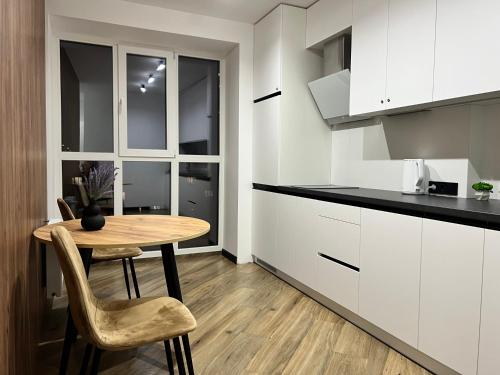 a kitchen with a table and chairs in a room at Апартаменти в районі АВТОВОКЗАЛУ Поблизу Обласноі лікарні ЖК Great House,ЖК Арена in Rivne