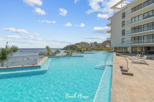 a swimming pool with a view of the ocean at Zantamar - Beachfront Suites in La Cruz in Cruz de Huanacaxtle