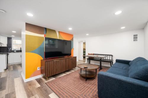 a living room with a blue couch and a kitchen at Chic 2-Bed Haven with Vibrant Décor in SE Atlanta in Atlanta