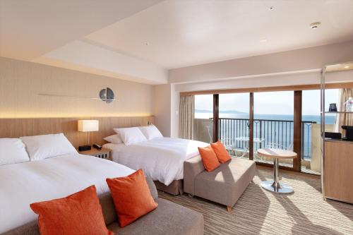 a hotel room with two beds and a balcony at AoAwo Naruto Resort in Naruto