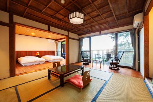 a bedroom with a bed and a table at Shukubo Komadori-Sanso in Ome