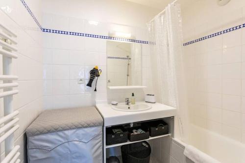 une salle de bain blanche avec un lavabo et un miroir dans l'établissement Le Botéro-T3 agréable, 2 chambres, balcon & garage, à Dinard