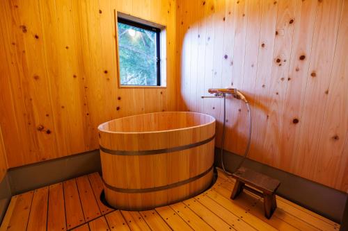 a wooden bathroom with a wooden tub in a room at Shukubo Komadori-Sanso in Ome