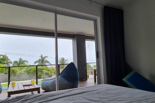 a bedroom with a large window with a view of a patio at Ballito Home, Private Pool & Solar in Ballito
