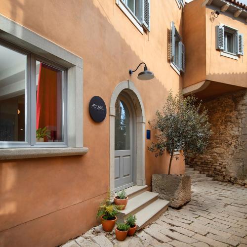 a door of a building with potted plants next to it at Mirakul Residence in a cute historic town in Labin