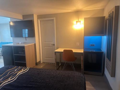 a bedroom with a desk and a bed with a chair at Super 8 by Wyndham Oceanside Downtown in Oceanside
