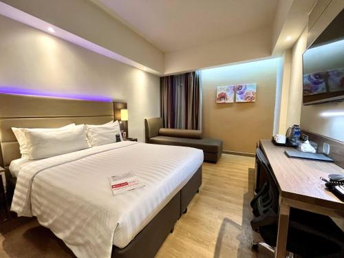 a hotel room with a bed and a desk at Bigland Hotel & Convention Sentul in Bogor