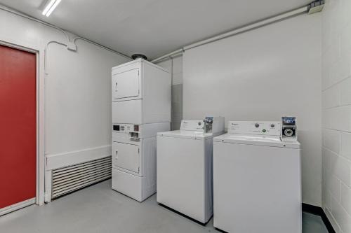 a laundry room with white appliances and a red door at Red Roof Inn & Suites Wilkesboro in Wilkesboro