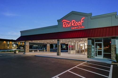 a restaurant with a red neon sign in a parking lot at Red Roof Inn & Suites Wilkesboro in Wilkesboro