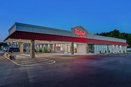 a store front with a neon sign in a parking lot at Red Roof Inn & Suites Wilkesboro in Wilkesboro