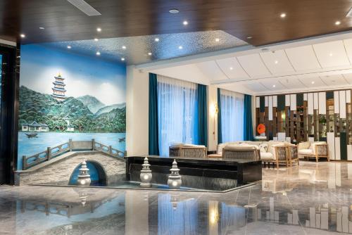 a lobby with a large painting on the wall at Nost algia S Hotel Hangzhou West Lake & Lingyin Temple 时光漫步S酒店杭州西湖店 Free laundry service, Free fresh ground coffee in Hangzhou