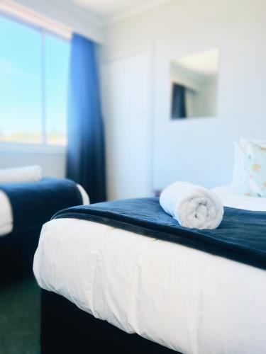 a hotel room with a bed with towels on it at Kurow Motel in Kurow