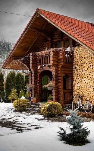 a log house with snow on the ground at Cabana Rustic Bran in Bran