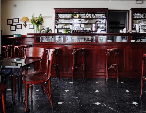 a bar with wooden bar stools in a restaurant at Hotel Slamič Ljubljana in Ljubljana