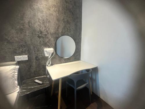 a small dressing table with a mirror on a wall at Jenny Homestay in Teluk Intan