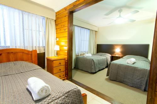 a hotel room with two beds and a mirror at Harvest Lodge Motel - Gunnedah in Gunnedah