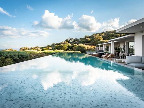 - une piscine avec vue sur une maison dans l'établissement Porto-Vecchio Palombaggia Villa Azaïtù, à Porto-Vecchio