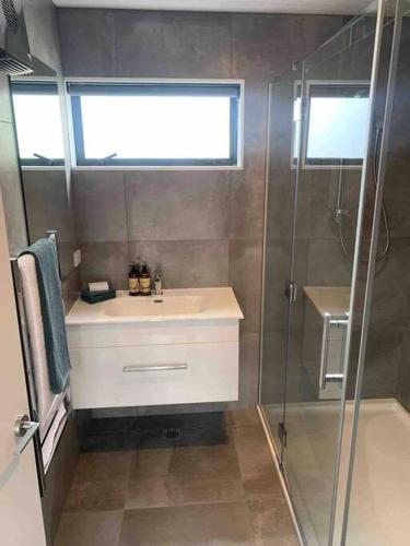 a bathroom with a sink and a shower at New State Of The Art Sunny Warm free Park in Christchurch