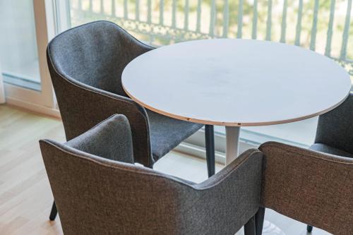a table and chairs with a white table and a table and chairs at Gyeongpo Soo Hotel in Gangneung