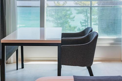 two chairs sitting at a desk in front of a window at Gyeongpo Soo Hotel in Gangneung