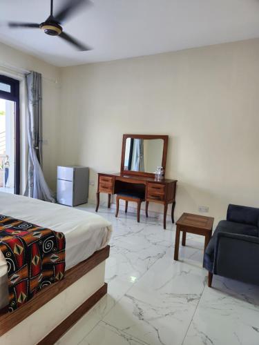 a bedroom with a bed and a chair and a desk at Cappadocia Hotel in Nungwi