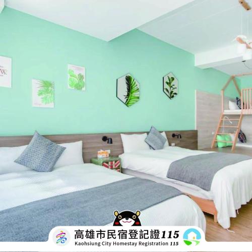 two beds in a room with blue walls at DoGoo in Kaohsiung