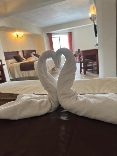 two swans made out of towels on the floor in a bedroom at Hotel Hacienda María Eugenia Acapulco in Acapulco