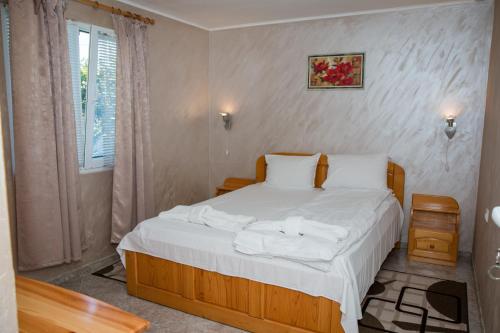 a bedroom with a bed with white sheets and a window at Summer House Christie in Krapets