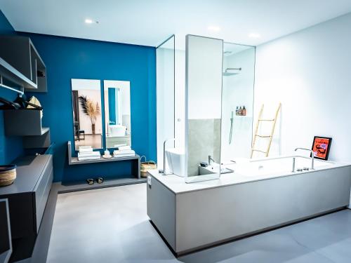 a bathroom with blue walls and a large white sink at Villa AzaiTu Suites in Porto-Vecchio