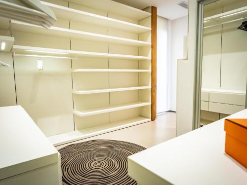 a walk in closet with white cabinets and a rug at Villa AzaiTu Suites in Porto-Vecchio