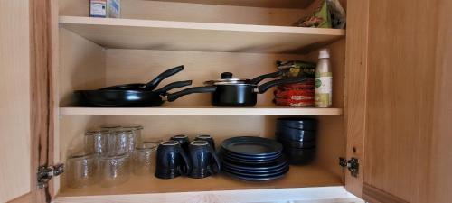 a cupboard with two pots and pans and plates at Lucky Guesthouse in Trapper Creek