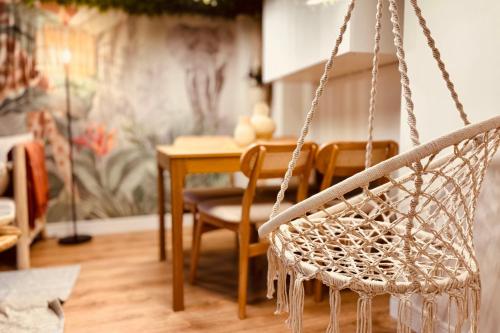 - une balançoire dans un salon avec une table dans l'établissement The Jungle - Superbe appartement au coeur de Lyon !, à Lyon