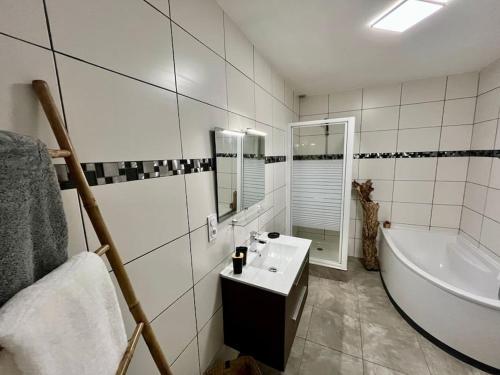 La salle de bains blanche est pourvue d'une baignoire, d'un lavabo et d'une baignoire. dans l'établissement La Catalane T4 Destination SaintCyp, à Saint-Cyprien