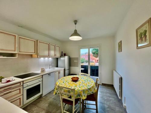 une cuisine avec une table et un chiffon de table jaune dans l'établissement La Catalane T4 Destination SaintCyp, à Saint-Cyprien