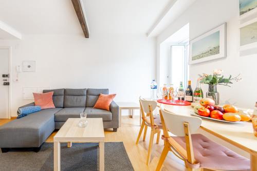 a living room with a couch and a table with fruit on it at Casas do Olival Apartments in Lisbon